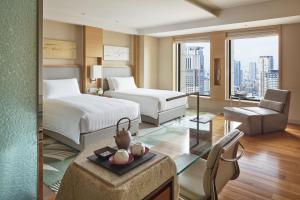 ein Hotelzimmer mit zwei Betten und einem Stuhl in der Unterkunft InterContinental Hotel Osaka by IHG in Osaka