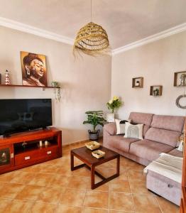 a living room with a couch and a flat screen tv at Villas Luins in Chiclana de la Frontera