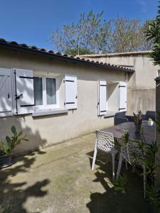 Una mesa y sillas frente a una casa en Maison aux portes des garrigues, en Nimes