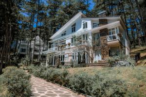 a white house on a hill with trees at Dahlia Dalat in Xuan An
