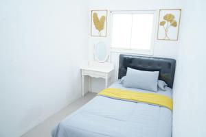 ein weißes Schlafzimmer mit einem Bett und einem Fenster in der Unterkunft Villa Safira Batu in Batu