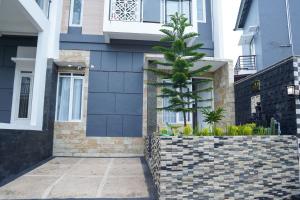 ein Haus mit einer Schutzwand und einer Palme in der Unterkunft Villa Safira Batu in Batu + 4 Fotos