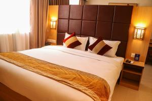 a bedroom with a large bed with a large headboard at Lumbini Green Hotel in Namāi
