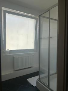 a bathroom with a window and a glass shower at Hannover Group Apartment in Hannover