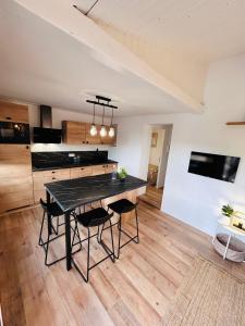 a large kitchen with a black table and chairs at Pinelodge Azure in Roquebrune-sur-Argens