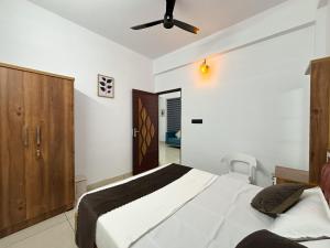 a bedroom with a bed and a ceiling fan at Lakshmi Home in Trichūr +1 photo