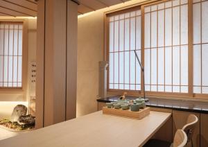 a room with windows and a table and chairs at UH Suite Central Seoul in Seoul