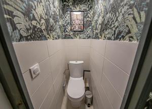 a small bathroom with a toilet and wallpaper at Le gîte des Remparts in Vignot +12 photos