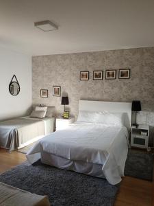 ein Schlafzimmer mit zwei Betten und einer Wand mit Bildern in der Unterkunft A Mouta in Amoedo