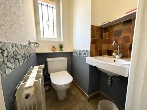 un baño con inodoro y lavabo en Maison en pierre Les Chardonnerets avec piscine, en Beynac-et-Cazenac 18 fotos más