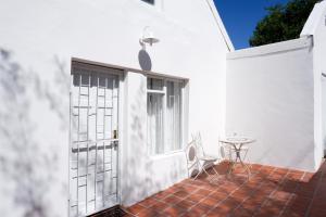 a white building with a door and a table at Karoo Zen in De Rust