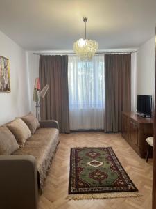 a living room with a couch and a chandelier at Panoramic Apartment in Gherla