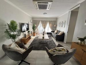 a living room with couches and a table at Shamba Self-Catering in Pretoria