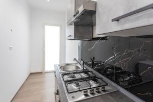a kitchen with a stove and a sink at ApartHotel Angelo - Salento Reservation in Racale