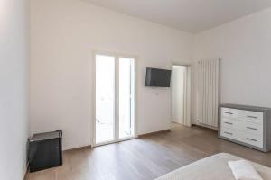 a bedroom with white walls and a bed and a dresser at ApartHotel Angelo - Salento Reservation in Racale