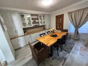 a dining room with a wooden table and chairs at Shamba Self-Catering in Pretoria