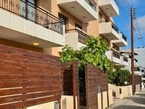une clôture en bois devant un bâtiment dans l'établissement The Fig Tree Apartment, à Aglantzia
