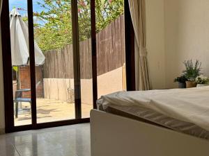 une chambre avec un lit et une porte coulissante en verre dans l'établissement The Fig Tree Apartment, à Aglantzia