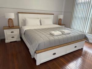 a bedroom with a bed with two towels on it at Beryls House in Coffs Harbour