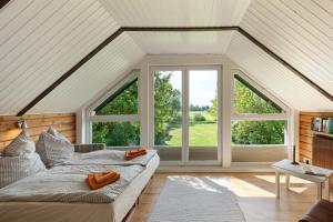 two beds in a room with large windows at Ferienhaus Schleiblick Gunneby in Ulsnis