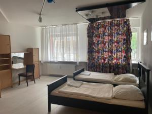 Un dormitorio con dos camas y una cortina. en City Light Hannover, en Hannover