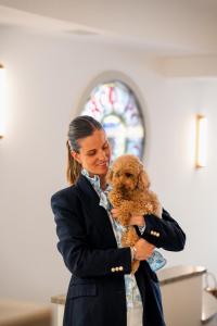 a woman holding a small dog in a church at Hotel Marco Polo in Lido di Jesolo
