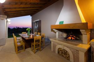 a dining room with a table and a fireplace at Villa Roza by Briskva in Bašići