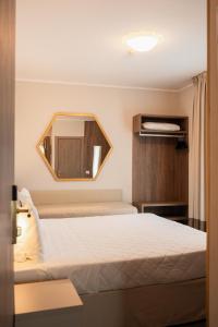 a hotel room with a bed and a mirror at Hotel Marco Polo in Lido di Jesolo