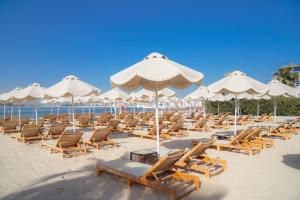 a bunch of chairs and umbrellas on a beach at NH Collection Dubai The Palm in Dubai