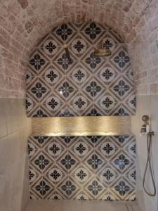 a shower in a bathroom with a tiled wall at I Trulli di Nonna Maria in Alberobello
