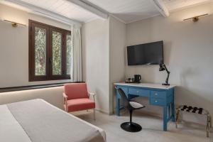 a bedroom with a desk and a tv and a chair at Villa Felicia in Noto