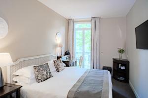 a bedroom with a white bed and a window at Le Cavendish in Cannes