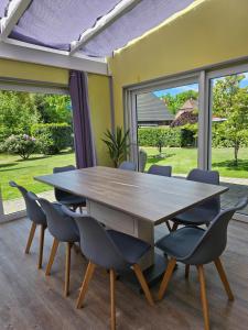 a wooden table and chairs in a room with windows at Roschi's Gästehaus in Gudow