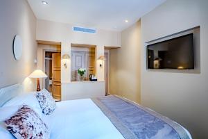 a bedroom with a bed and a flat screen tv at Le Cavendish in Cannes