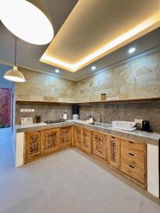 cocina grande con armarios de madera y encimera grande en Villa Tenang, en Ubud