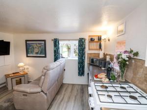 een keuken met een bank en een stoel in een kamer bij Wayside Farm Cart Cottage in Scarborough