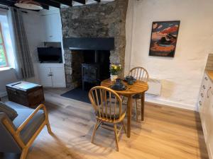 Una sala de estar con mesa y sillas y una chimenea. en 4 Old Tanrhiw, en Caernarfon