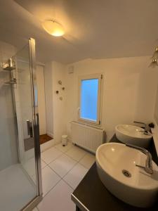 Un baño con dos lavabos y una ducha de cristal. en La Mylandie, en Wimille 24 fotos más