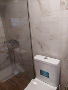 a bathroom with a white toilet and a shower at il vicolo studio in Ágios Matthaíos