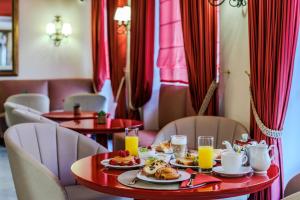 a table with plates of food and orange juice at Le Cavendish in Cannes