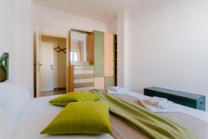1 dormitorio con cama con almohadas verdes y espejo en Casa Rossella a Otranto, en Otranto