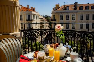 a table with food and drinks on a balcony at Le Cavendish in Cannes