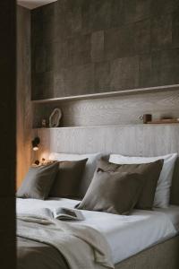 a bedroom with a bed with white sheets and pillows at Apartamenty Marina Rogowo- nowoczesne apartamenty z tarasem- 200m do plaży- między morzem, a jeziorem Resko, parking w cenie! in Rogowo