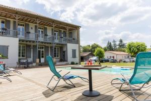 a patio with chairs and a table and a pool at Les rives de l'escamat in Sabres