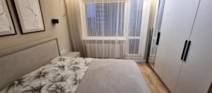 a small bedroom with a bed and a window at New 2-Room Apartment near Sportivnaya Харьков, Тарасенка 92а in Dobrovelychkivka