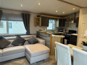 a living room with a couch and a kitchen at Haggerston Castle No 71 in Beal