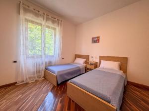 two beds in a room with a window at Casa Terra Holiday in Padenghe sul Garda