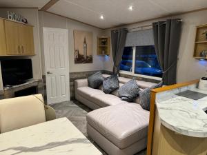 a caravan living room with couches and a window at Haggerston Castle No 71 in Beal