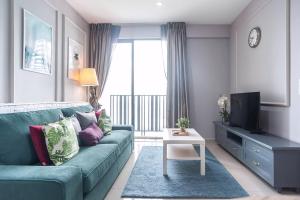 a living room with a blue couch and a tv at I-City Luxury Condominiums, Shah Alam by Smarthome in Shah Alam