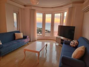 Una sala de estar con dos sofás azules y un televisor. en Toros Villa 37, en Kargicak